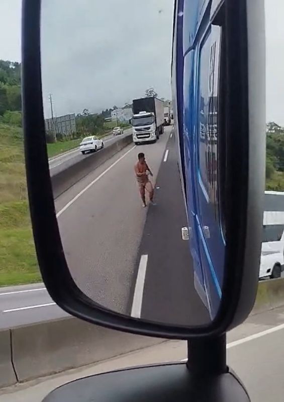 Homem corre entre carris e tenta subir em caminhões na BR 101